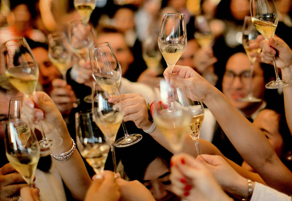 Guests enjoying a glass of champagne, at a discreet religious wedding in Europe, led by a rabbi. 